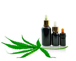 Bottle with CBD oil and cannabis leaf at white background, medic